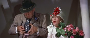 Movie still from “Auntie Mame” (1958), directed by Morton DaCosta – An older man and a young woman in a hat; Close Up shot, Low angle