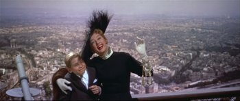 Movie still from “Auntie Mame” (1958), directed by Morton DaCosta – A woman and a boy standing next to each other on top of a building; Medium shot, High angle