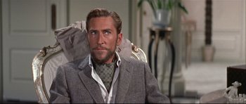 Movie still from “Auntie Mame” (1958), directed by Morton DaCosta – A person sitting in a chair wearing a suit; Close Up shot, Over the shoulder angle