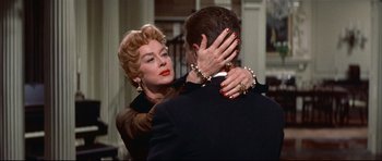 Movie still from “Auntie Mame” (1958), directed by Morton DaCosta – An older woman is hugging a younger man; Close Up shot, Over the shoulder angle