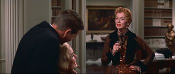 Movie still from “Auntie Mame” (1958), directed by Morton DaCosta – A man and a woman talking to another woman in a room; Medium shot, Over the shoulder angle