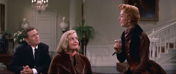 Movie still from “Auntie Mame” (1958), directed by Morton DaCosta – Two women are talking and smiling in a living room; Medium shot, Over the shoulder angle