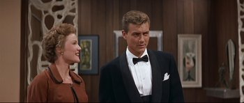 Movie still from “Auntie Mame” (1958), directed by Morton DaCosta – A man in a suit and a woman in a dress; Medium shot, Over the shoulder angle