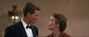 Movie still from “Auntie Mame” (1958), directed by Morton DaCosta – A man and a woman are looking at one another; Close Up shot, Low angle