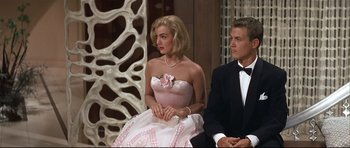 Movie still from “Auntie Mame” (1958), directed by Morton DaCosta – A man and a woman sitting on a bench; Medium shot, Low angle