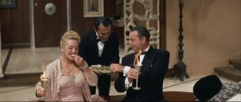 Movie still from “Auntie Mame” (1958), directed by Morton DaCosta – A group of people sitting at a table eating food; Medium shot, High angle