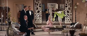Movie still from “Auntie Mame” (1958), directed by Morton DaCosta – A group of people standing in a room; Wide shot, High angle