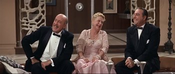 Movie still from “Auntie Mame” (1958), directed by Morton DaCosta – A man and a woman sitting next to each other; Medium shot, High angle