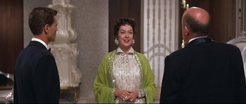 Movie still from “Auntie Mame” (1958), directed by Morton DaCosta – A woman in a white dress and a lime green jacket; Medium shot, Over the shoulder angle