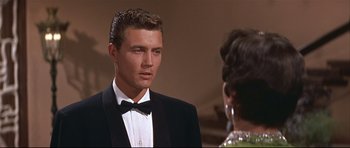 Movie still from “Auntie Mame” (1958), directed by Morton DaCosta – A man wearing a tuxedo and a bow tie; Close Up shot, Over the shoulder angle