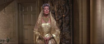 Movie still from “Auntie Mame” (1958), directed by Morton DaCosta – A woman in a gold dress and a gold crown; Medium shot, Low angle