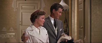 Movie still from “Auntie Mame” (1958), directed by Morton DaCosta – A man and a woman standing next to each other; Medium shot, Over the shoulder angle