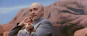 Movie still from “Austin Powers in Goldmember” (2002), directed by Jay Roach – A bald headed man holding a cat in his hands; Medium shot, Low angle