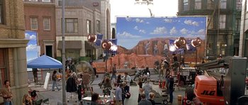 Movie still from “Austin Powers in Goldmember” (2002), directed by Jay Roach – A group of people standing around in front of a large screen; Extreme Wide shot, High angle