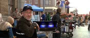Movie still from “Austin Powers in Goldmember” (2002), directed by Jay Roach – A man in a hat and glasses is sitting in front of a laptop; Medium shot, Over the shoulder angle