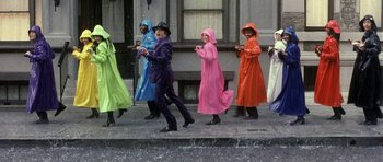 Movie still from “Austin Powers in Goldmember” (2002), directed by Jay Roach – A group of people walking down the street in raincoats; Wide shot, High angle