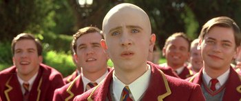 Movie still from “Austin Powers in Goldmember” (2002), directed by Jay Roach – A man with a bald head is standing next to another man; Close Up shot, Low angle
