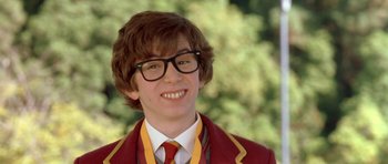 Movie still from “Austin Powers in Goldmember” (2002), directed by Jay Roach – A young man wearing a suit and tie smiling for the camera; Close Up shot, High angle