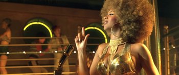 Movie still from “Austin Powers in Goldmember” (2002), directed by Jay Roach – A woman in a gold outfit singing into a microphone; Close Up shot, Low angle