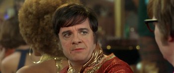 Movie still from “Austin Powers in Goldmember” (2002), directed by Jay Roach – A person wearing a costume; Close Up shot, Over the shoulder angle