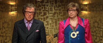 Movie still from “Austin Powers in Goldmember” (2002), directed by Jay Roach – A man and a woman standing next to each other; Medium shot, Low angle