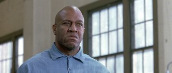 Movie still from “Austin Powers in Goldmember” (2002), directed by Jay Roach – A bald man in a blue shirt is looking at the camera; Close Up shot, Low angle