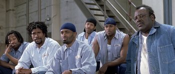 Movie still from “Austin Powers in Goldmember” (2002), directed by Jay Roach – A group of men sitting next to each other; Medium shot, Over the shoulder angle