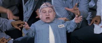 Movie still from “Austin Powers in Goldmember” (2002), directed by Jay Roach – An image of a man that is wearing a shirt and a tie; Medium shot, Low angle