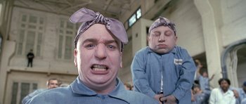 Movie still from “Austin Powers in Goldmember” (2002), directed by Jay Roach – A man with a bandana on his head and a man with a bandana on his face; Medium shot, Low angle