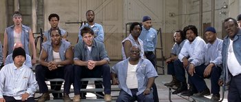 Movie still from “Austin Powers in Goldmember” (2002), directed by Jay Roach – A group of men sitting on top of a wooden bench; Wide shot, High angle