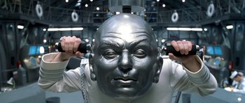 Movie still from “Austin Powers in Goldmember” (2002), directed by Jay Roach – A man with a metal head and chains around his neck; Close Up shot, Low angle