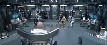 Movie still from “Austin Powers in Goldmember” (2002), directed by Jay Roach – A group of people sitting in a circle in front of a building; Extreme Wide shot, High angle