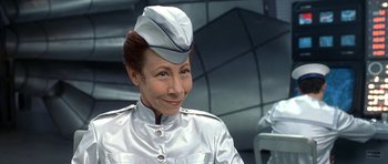 Movie still from “Austin Powers in Goldmember” (2002), directed by Jay Roach – A woman wearing a silver uniform and a hat; Close Up shot, Low angle