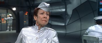 Movie still from “Austin Powers in Goldmember” (2002), directed by Jay Roach – An older woman wearing a silver uniform and a hat; Close Up shot, Low angle