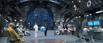 Movie still from “Austin Powers in Goldmember” (2002), directed by Jay Roach – Two men are standing in front of a giant globe in a room; Extreme Wide shot, High angle