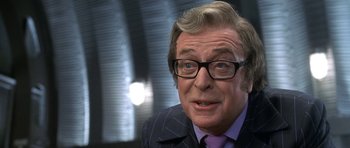 Movie still from “Austin Powers in Goldmember” (2002), directed by Jay Roach – A person wearing a suit and glasses; Close Up shot, Over the shoulder angle