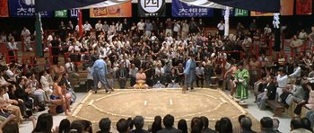 Movie still from “Austin Powers in Goldmember” (2002), directed by Jay Roach – A sumo wrestling match in front of a crowd of people; Extreme Wide shot, High angle