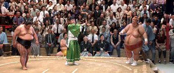 Movie still from “Austin Powers in Goldmember” (2002), directed by Jay Roach – A man in a green outfit is performing a sword fight; Wide shot, Low angle