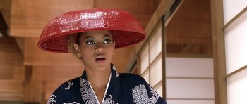 Movie still from “Austin Powers in Goldmember” (2002), directed by Jay Roach – A woman wearing a kimono and a red hat; Close Up shot, Low angle