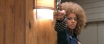Movie still from “Austin Powers in Goldmember” (2002), directed by Jay Roach – A woman holding a gun in a room; Close Up shot, Low angle