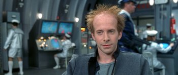 Movie still from “Austin Powers in Goldmember” (2002), directed by Jay Roach – A man with spiky brown hair is standing in front of a computer screen; Close Up shot, Low angle