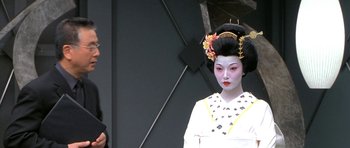 Movie still from “Austin Powers in Goldmember” (2002), directed by Jay Roach – A geisha in a white dress with a black and yellow headdress; Close Up shot, Over the shoulder angle