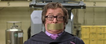 Movie still from “Austin Powers in Goldmember” (2002), directed by Jay Roach – A man with a tape over his mouth; Close Up shot, Over the shoulder angle