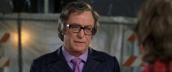 Movie still from “Austin Powers in Goldmember” (2002), directed by Jay Roach – A person wearing a suit and tie; Close Up shot, Over the shoulder angle