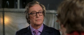 Movie still from “Austin Powers in Goldmember” (2002), directed by Jay Roach – An older man wearing a suit and purple tie; Close Up shot, Over the shoulder angle