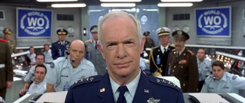 Movie still from “Austin Powers in Goldmember” (2002), directed by Jay Roach – A man in a uniform in front of other men; Close Up shot, Low angle