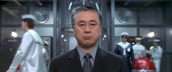 Movie still from “Austin Powers in Goldmember” (2002), directed by Jay Roach – A man in a suit and tie in a room; Close Up shot, Low angle