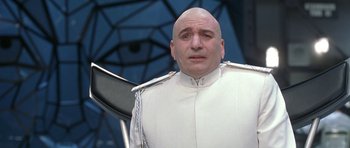 Movie still from “Austin Powers in Goldmember” (2002), directed by Jay Roach – A bald man in a white suit is looking at the camera; Close Up shot, Low angle