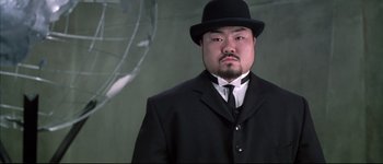 Movie still from “Austin Powers: International Man of Mystery” (1997), directed by Jay Roach – A man wearing a suit and a black hat; Close Up shot, Low angle