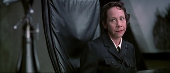 Movie still from “Austin Powers: International Man of Mystery” (1997), directed by Jay Roach – A person sitting in a chair wearing a uniform; Close Up shot, Over the shoulder angle